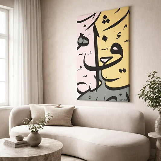 Modern living room with a white sofa, round coffee table, and abstract Arabic calligraphy artwork on the wall.
